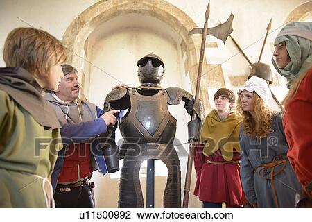 Stock Image - Students examining suit of armor. Fotosearch