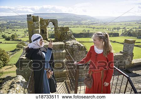 Stock Image - Students in period dress at castle. Fotosearch