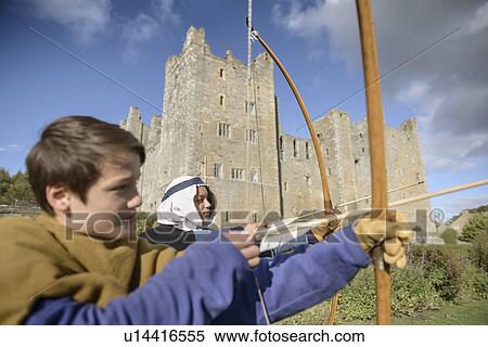 Stock Photography - Students in period dress shooting arrows. Fotosearch