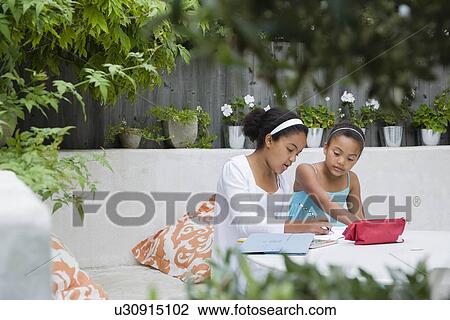 Stock Image - Students working together outdoors. Fotosearch