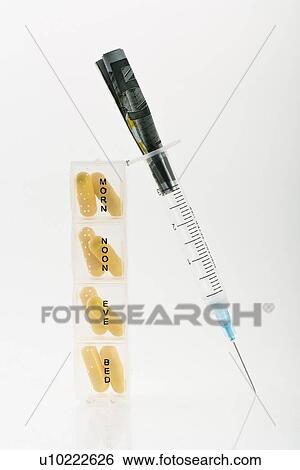 Stock Photograph - Syringe with portions of pills. Fotosearch
