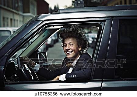 Stock Photograph - Teenage boy driving on city street. Fotosearch