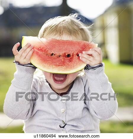 Picture - Toddler girl playing with watermelon. Fotosearch