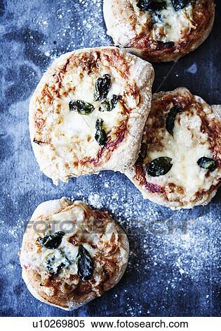Stock Photography - Tray of pizzas with herbs. Fotosearch