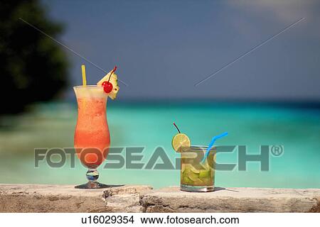 Tropical drinks on rock wall View Large Photo Image Picture - Tropical drinks on rock wall. Fotosearch