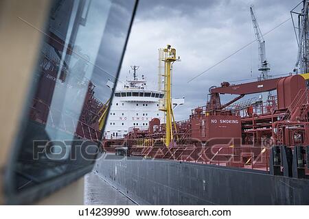 Stock Image - Tugboat overlooking stern of ship. Fotosearch