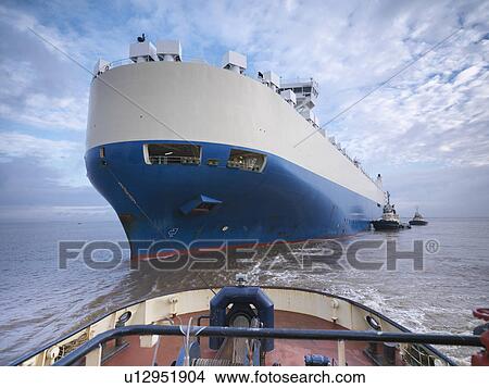Tugboat pushing large boat out to sea View Large Photo Image Picture - Tugboat pushing large boat out to sea. Fotosearch