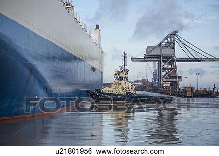 Tugboat pushing ship in harbor View Large Photo Image Stock Photograph - Tugboat pushing ship in harbor. Fotosearch
