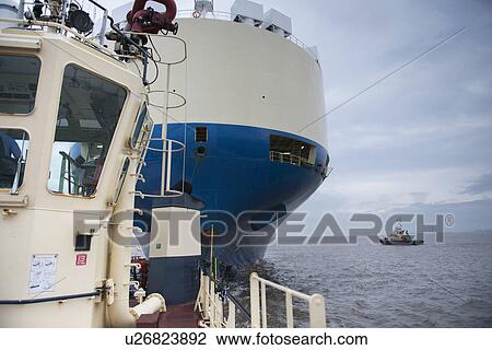 Tugboat towing ship to harbor View Large Photo Image Stock Image - Tugboat towing ship to harbor. Fotosearch