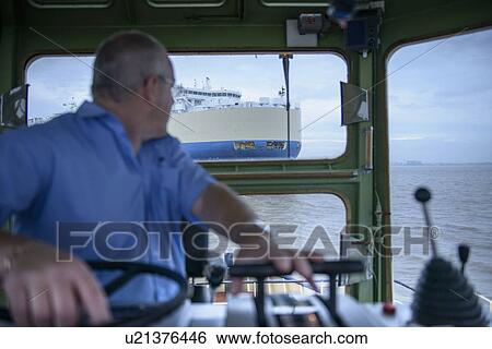 Stock Photograph - Tugboat towing ship to harbor. Fotosearch