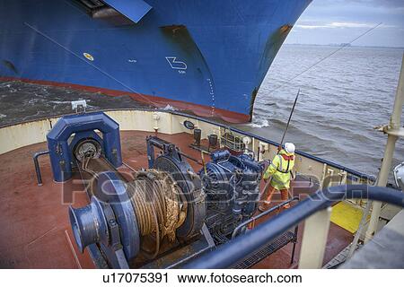 Tugboat worker catching rope on deck View Large Photo Image Stock Image - Tugboat worker catching rope on deck. Fotosearch