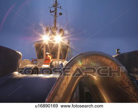 Stock Photo - Tugboat worker standing on deck. Fotosearch