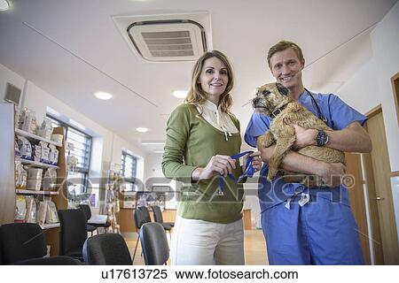 Veterinarian holding dog in lobby View Large Photo Image Stock Photography - Veterinarian holding dog in lobby. Fotosearch