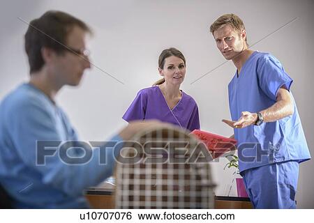 Veterinarians talking in office View Large Photo Image Stock Photograph - Veterinarians talking in office. Fotosearch