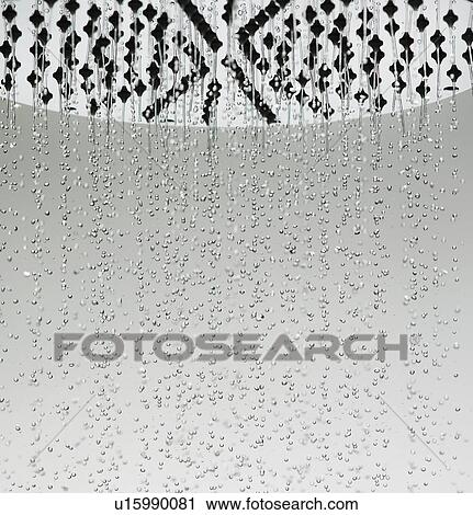 Stock Image - Water drops falling from shower head. Fotosearch