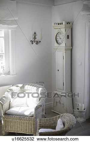 Wicker chairs and clock in living room View Large Photo Image Stock Image - Wicker chairs and clock in living room. Fotosearch