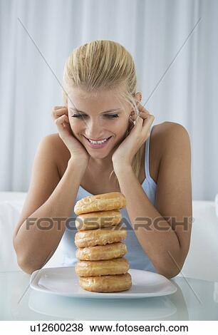 Stock Photo - Woman admiring stack of donuts. Fotosearch