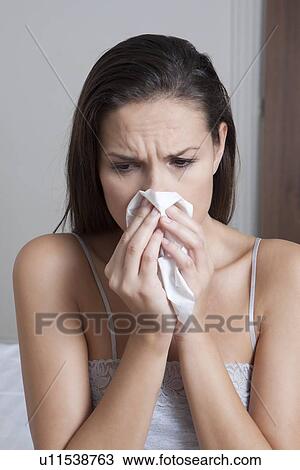 Woman blowing her nose on bed View Large Photo Image Stock Image - Woman blowing her nose on bed. Fotosearch