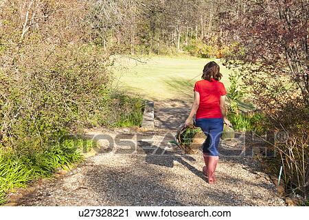 Woman carrying basket of plants outdoors View Large Photo Image Stock Image - Woman carrying basket of plants outdoors. Fotosearch