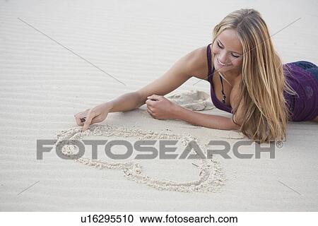 Woman drawing in sand on beach View Large Photo Image Stock Image - Woman drawing in sand on beach. Fotosearch