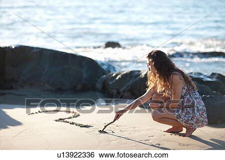 Woman drawing question mark in sand View Large Photo Image Stock Photograph - Woman drawing question mark in sand. Fotosearch