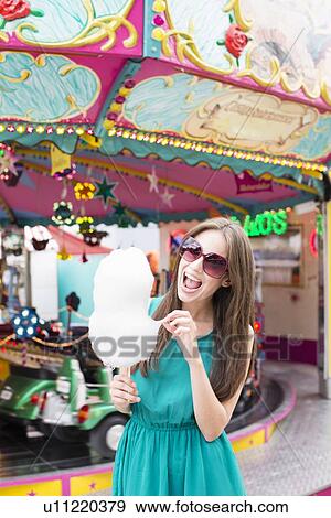 Woman eating cotton candy at fair View Large Photo Image Stock Photo - Woman eating cotton candy at fair. Fotosearch