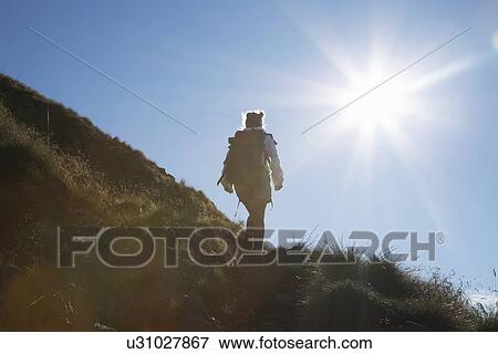 Stock Photo - Woman hiking on rural hillside. Fotosearch