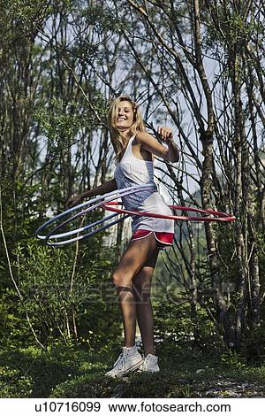 Woman hula hooping in forest View Large Photo Image Stock Photo - Woman hula hooping in forest. Fotosearch