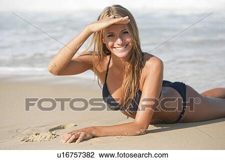 Woman in bikini laying on beach View Large Photo Image Stock Image - Woman in bikini laying on beach. Fotosearch