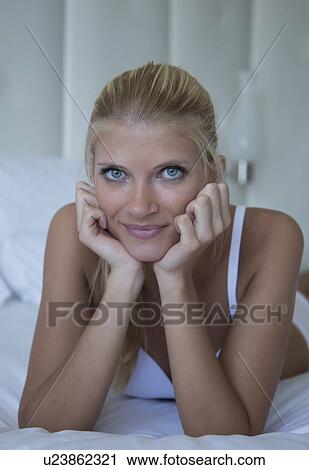 Woman laying on elbows on bed View Large Photo Image Stock Image - Woman laying on elbows on bed. Fotosearch