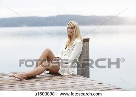 Woman leaning on post on wooden deck View Large Photo Image Stock Image - Woman leaning on post on wooden deck. Fotosearch