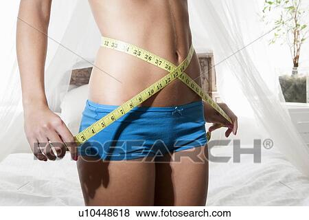 Woman measuring her belly with tape View Large Photo Image Stock Photo - Woman measuring her belly with tape. Fotosearch