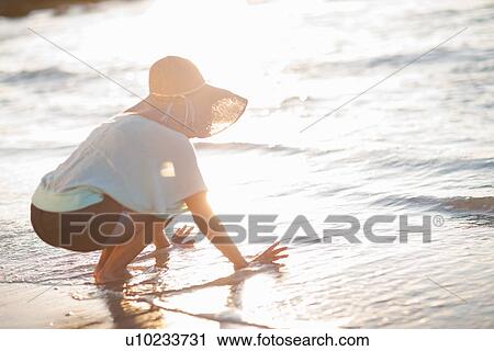 Woman playing in waves at beach View Large Photo Image Stock Image - Woman playing in waves at beach. Fotosearch
