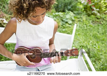 Woman playing ukulele in backyard View Large Photo Image Stock Image - Woman playing ukulele in backyard. Fotosearch