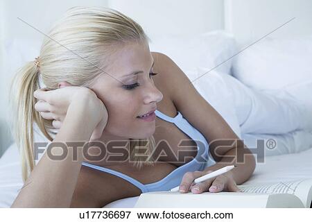 Woman reading book in bed View Large Photo Image Stock Photo - Woman reading book in bed. Fotosearch