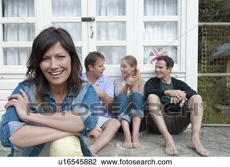Woman sitting with family outside house View Large Photo Image Stock Image - Woman sitting with family outside house. Fotosearch