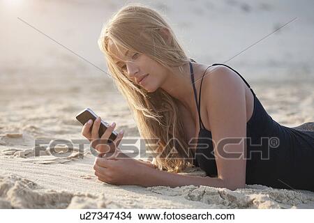 Woman using cell phone on beach View Large Photo Image Picture - Woman using cell phone on beach. Fotosearch