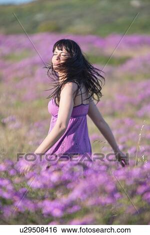 Woman walking in field of flowers View Large Photo Image Stock Photograph - Woman walking in field of flowers. Fotosearch