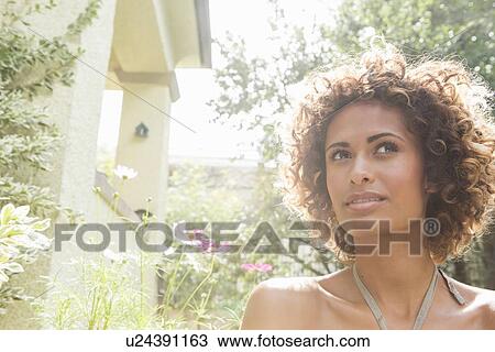 Stock Image - Woman walking in garden. Fotosearch