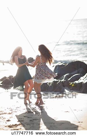 Stock Photograph - Women dancing together on beach. Fotosearch