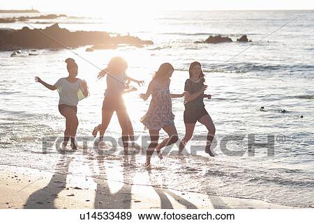 Women running together on beach View Large Photo Image Stock Photo - Women running together on beach. Fotosearch