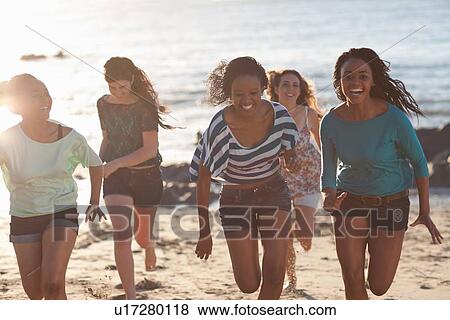 Women running together on beach View Large Photo Image Stock Photo - Women running together on beach. Fotosearch