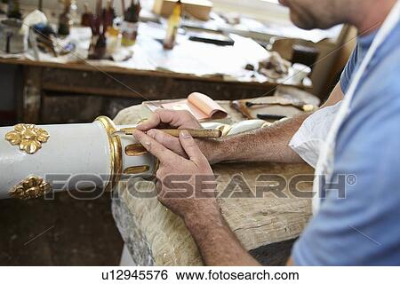 Worker applying gold leaf to pole View Large Photo Image Stock Photograph - Worker applying gold leaf to pole. Fotosearch