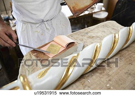 Worker applying gold leaf to pole View Large Photo Image Stock Photography - Worker applying gold leaf to pole. Fotosearch
