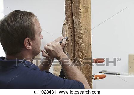 Worker chiseling figure from wood View Large Photo Image Stock Image - Worker chiseling figure from wood. Fotosearch