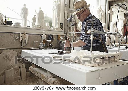 Worker chiseling slab of stone View Large Photo Image Stock Photo - Worker chiseling slab of stone. Fotosearch