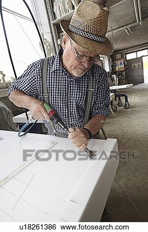 Stock Photograph - Worker chiseling slab of stone. Fotosearch