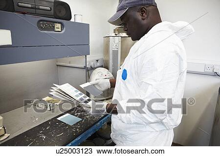 Stock Image - Worker matching paint to swatches. Fotosearch
