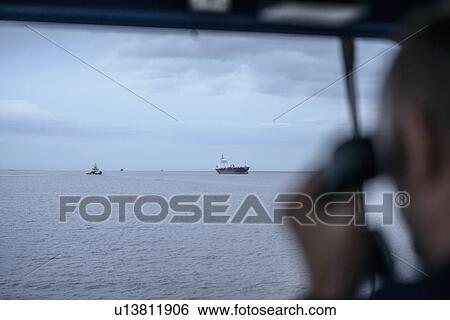 Worker on tugboat talking on phone View Large Photo Image Stock Photograph - Worker on tugboat talking on phone. Fotosearch