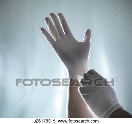Stock Photography - Worker pulling on latex gloves. Fotosearch